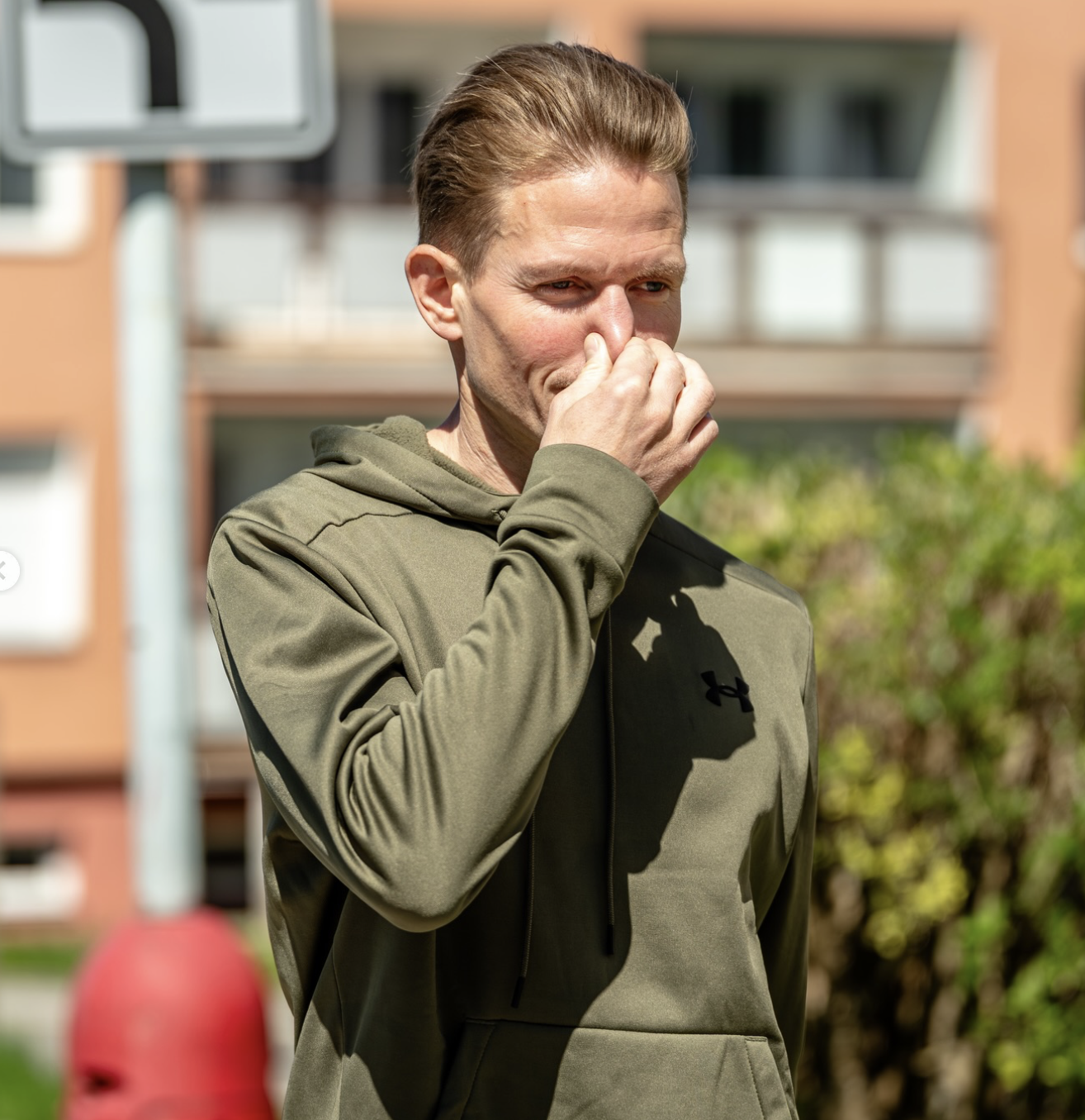 Jiří Květoň venku v zelené mikině si při dechovém cvičení drží nos